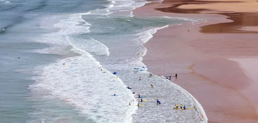Surfers In The Waves Off Mawga, Cornwall