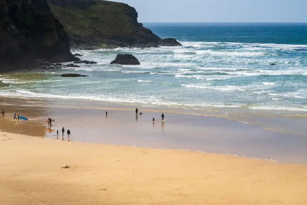Surfers and bodyboarders get ready to hit the waves at Mawgan Porth Beach, Newquay, Cornwall