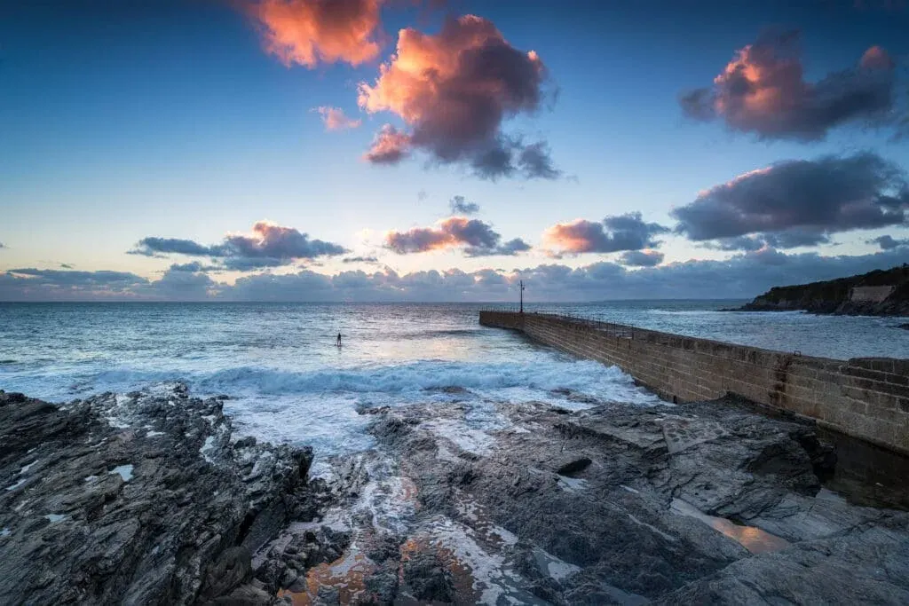 A dramatic sunset overlooks Porthleven Beach and harbour